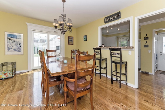 720 Linden St, East Lansing, MI 48823 - dining room with a chandelier, wood finished floors, healthy amount of natural light, and crown molding