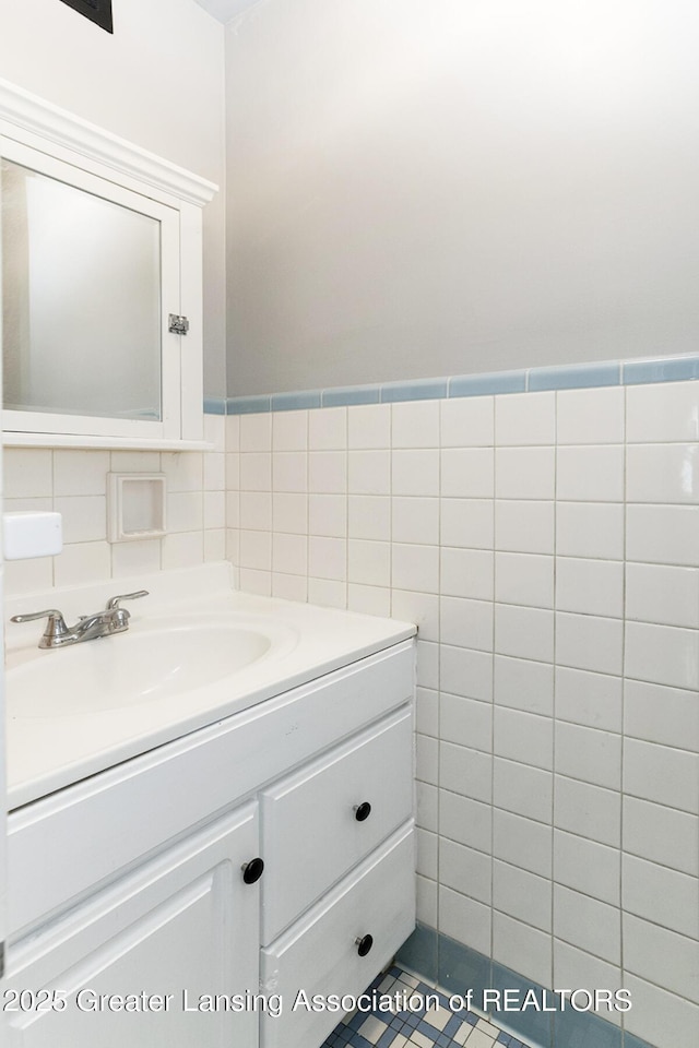 720 Linden St, East Lansing, MI 48823 - bathroom featuring vanity, tile walls, and wainscoting
