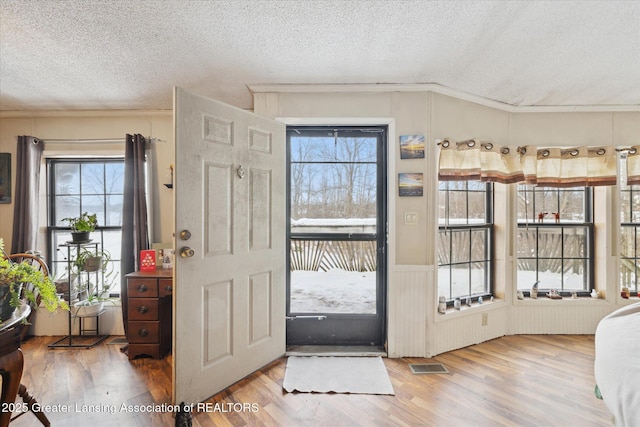 9428 S Wright Rd, Eagle, MI 48822 - foyer entrance featuring a textured ceiling, wood finished floors, and crown molding