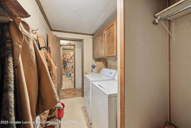 9428 S Wright Rd, Eagle, MI 48822 - washroom featuring washing machine and dryer, cabinet space, a textured ceiling, and light flooring