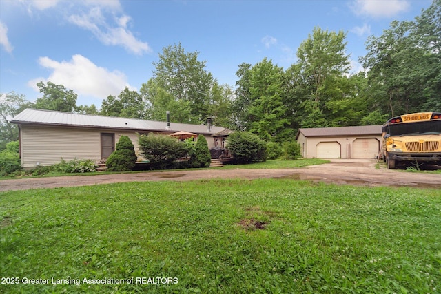 9428 S Wright Rd, Eagle, MI 48822 - view of front of home with an outdoor structure, driveway, a front lawn, a garage, and a metal roof