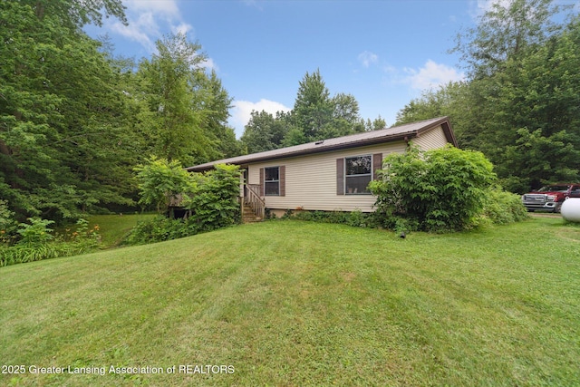9428 S Wright Rd, Eagle, MI 48822 - view of side of home featuring a yard and a metal roof