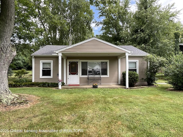 315 Oyer St, Springport, MI 49284 - bungalow-style home with a front yard, roof with shingles, and a porch