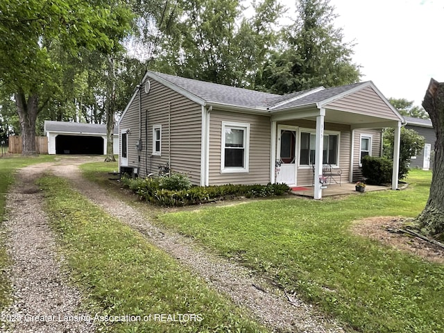 315 Oyer St, Springport, MI 49284 - single story home featuring an outbuilding, a porch, a front yard, and roof with shingles