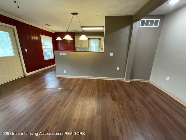 315 Oyer St, Springport, MI 49284 - kitchen featuring dark wood finished floors, plenty of natural light, pendant lighting, ornamental molding, and a peninsula