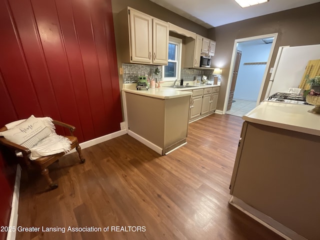 315 Oyer St, Springport, MI 49284 - kitchen with light countertops, wood finished floors, tasteful backsplash, stainless steel microwave, and a peninsula