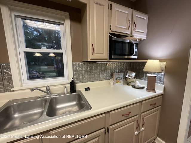 315 Oyer St, Springport, MI 49284 - kitchen with stainless steel microwave, light countertops, and decorative backsplash