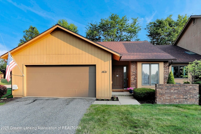 1621 Willow Creek Dr, Lansing, MI 48917 - view of front of house with roof with shingles, a garage, a front yard, and brick siding