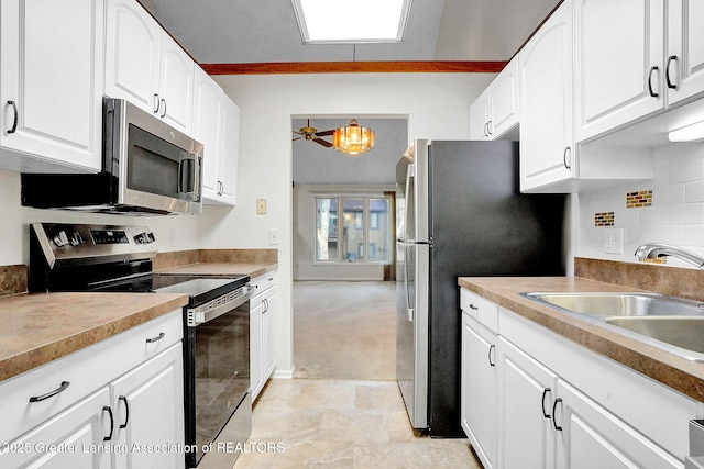 1621 Willow Creek Dr, Lansing, MI 48917 - kitchen featuring stainless steel appliances, a chandelier, white cabinets, backsplash, and light countertops