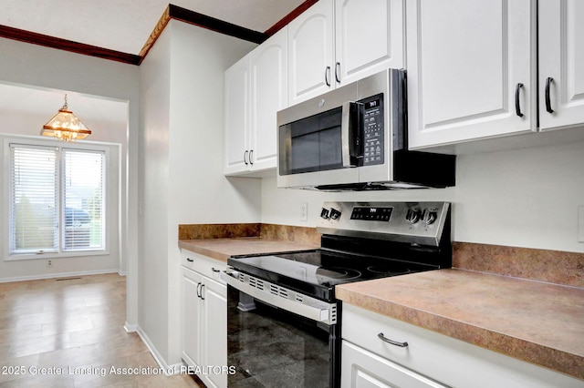 1621 Willow Creek Dr, Lansing, MI 48917 - kitchen with stainless steel appliances, white cabinetry, hanging light fixtures, ornamental molding, and light countertops