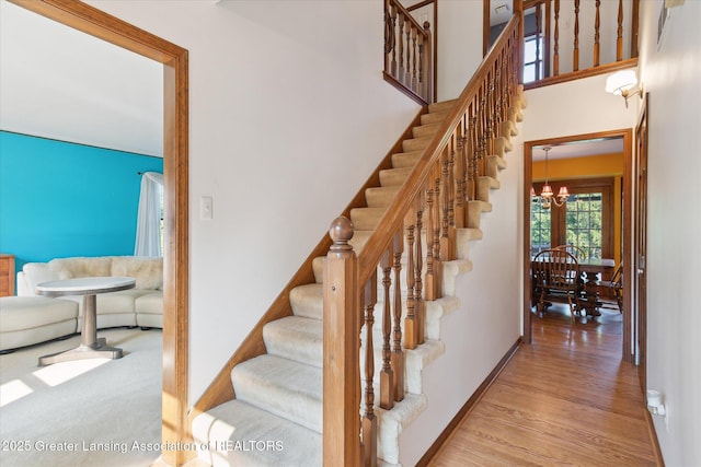 9303 Blueberry Ct, Howell, MI 48843 - stairs featuring a chandelier and wood finished floors
