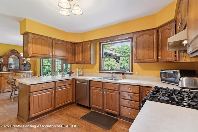 9303 Blueberry Ct, Howell, MI 48843 - kitchen with light countertops, a peninsula, brown cabinetry, and light wood-style flooring