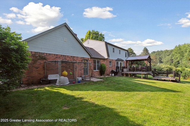9303 Blueberry Ct, Howell, MI 48843 - back of house featuring a gazebo, brick siding, a wooden deck, and a yard