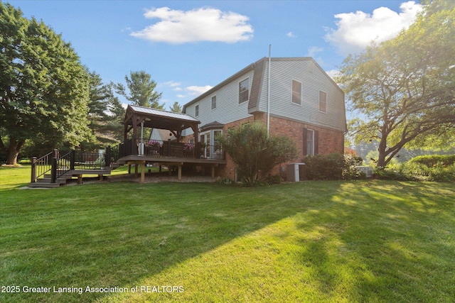 9303 Blueberry Ct, Howell, MI 48843 - rear view of house featuring a gazebo, a deck, brick siding, and a yard