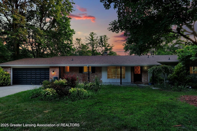 2315 Hamilton Rd, Okemos, MI 48864 - ranch-style house with a garage, driveway, a yard, brick siding, and a shingled roof