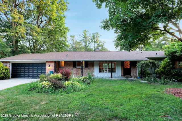 2315 Hamilton Rd, Okemos, MI 48864 - ranch-style house featuring an attached garage, a porch, driveway, a front yard, and brick siding