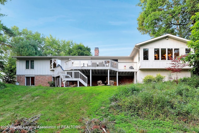 2315 Hamilton Rd, Okemos, MI 48864 - back of property with stairway, a wooden deck, a lawn, and a chimney