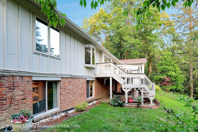2315 Hamilton Rd, Okemos, MI 48864 - back of house with board and batten siding, stairway, a lawn, and a wooden deck