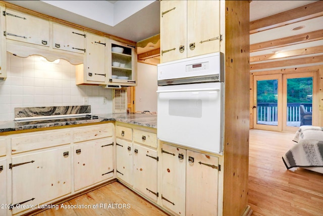 2315 Hamilton Rd, Okemos, MI 48864 - kitchen featuring light wood-style flooring, backsplash, oven, and dark countertops