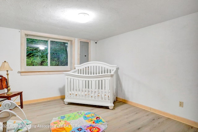 2315 Hamilton Rd, Okemos, MI 48864 - bedroom featuring wood finished floors and a crib