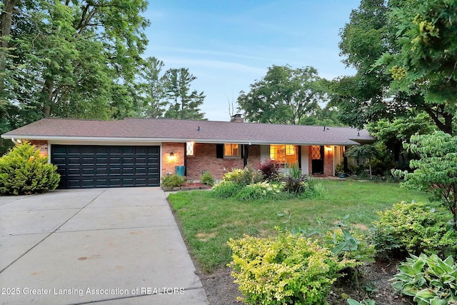 2315 Hamilton Rd, Okemos, MI 48864 - single story home with concrete driveway, a garage, a chimney, brick siding, and a front lawn