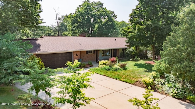 2315 Hamilton Rd, Okemos, MI 48864 - ranch-style home featuring a garage, roof with shingles, concrete driveway, brick siding, and a front yard