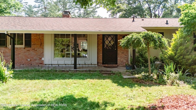 2315 Hamilton Rd, Okemos, MI 48864 - ranch-style home featuring brick siding, a front lawn, and a chimney