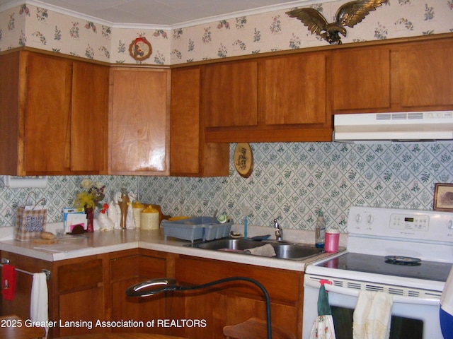1002 Water St, Eaton Rapids, MI 48827 - kitchen with white range with electric stovetop, light countertops, under cabinet range hood, wallpapered walls, and brown cabinets