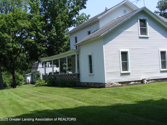 1002 Water St, Eaton Rapids, MI 48827 - view of side of home with covered porch, a yard, and roof with shingles