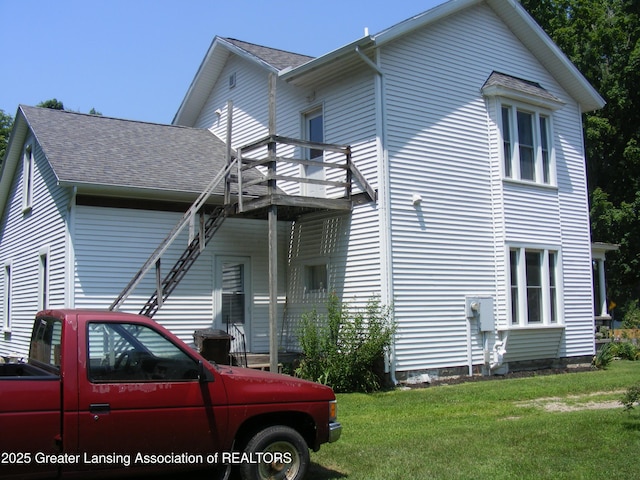 1002 Water St, Eaton Rapids, MI 48827 - view of property exterior featuring a shingled roof and a yard