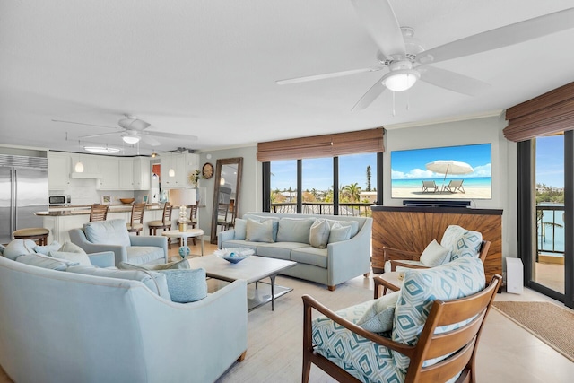 living area with light wood-style flooring and a ceiling fan