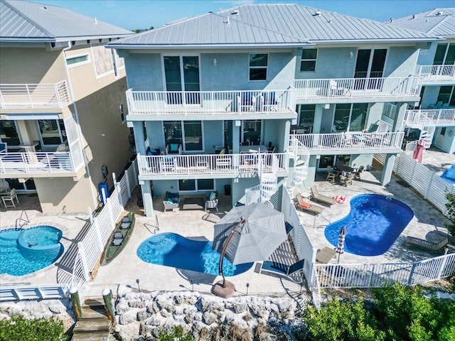 rear view of house with an outdoor hangout area, a jacuzzi, stucco siding, and a patio