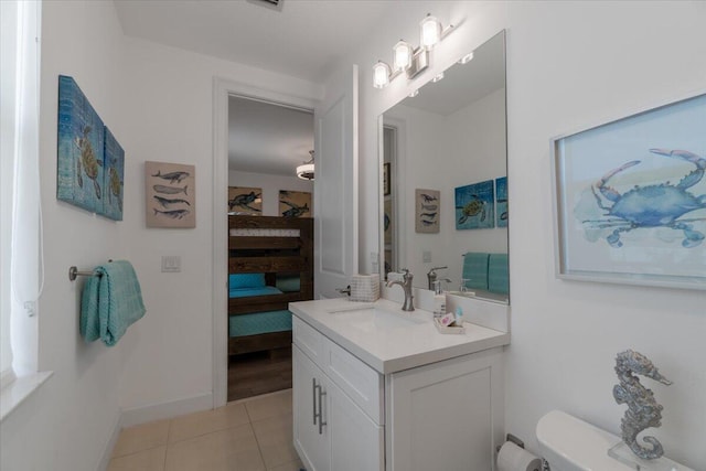 bathroom with baseboards, toilet, vanity, ensuite bath, and tile patterned flooring