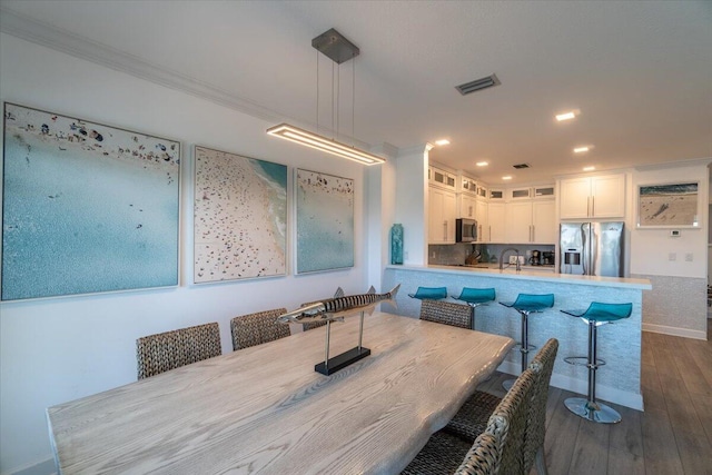 dining room with visible vents, recessed lighting, ornamental molding, and dark wood-type flooring