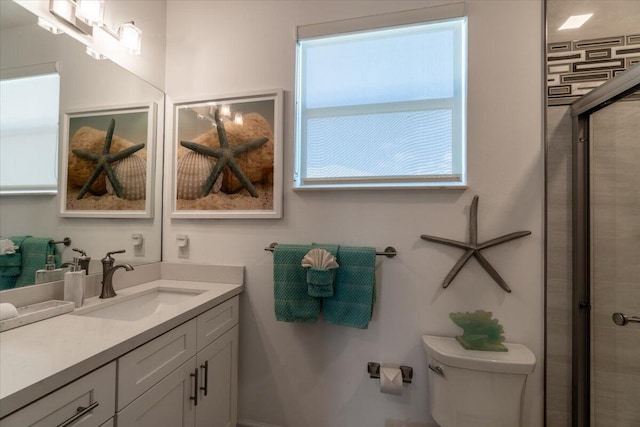 bathroom featuring a tile shower, toilet, and vanity
