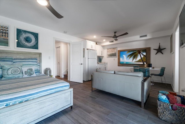 bedroom featuring baseboards, dark wood-style floors, visible vents, freestanding refrigerator, and a ceiling fan