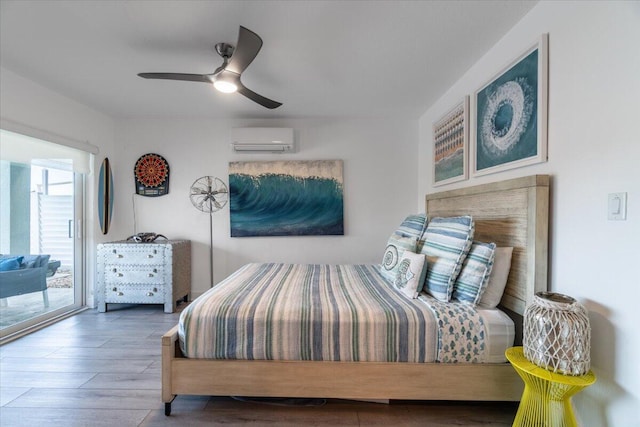 bedroom featuring a ceiling fan, wood finished floors, an AC wall unit, and access to outside