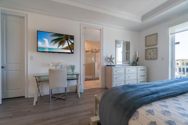bedroom with a tray ceiling, multiple windows, crown molding, and wood finished floors