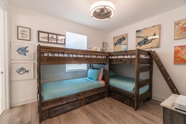 bedroom featuring baseboards and wood finished floors