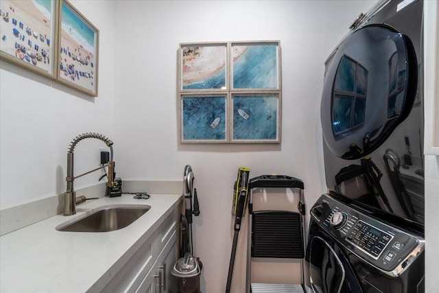 laundry room with a sink, cabinet space, and stacked washer / dryer