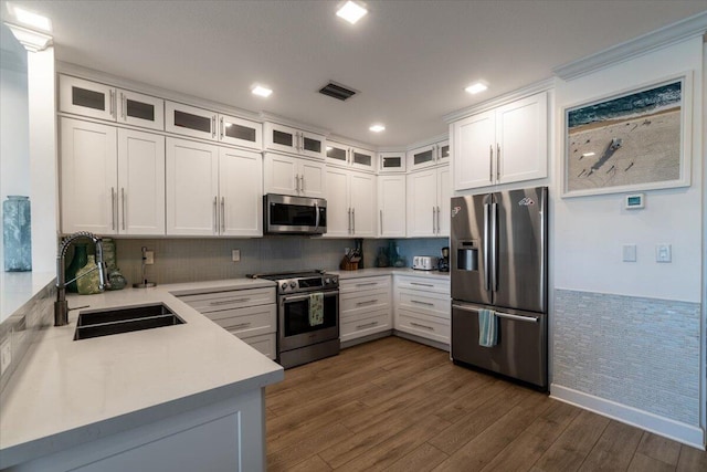 kitchen with light countertops, visible vents, appliances with stainless steel finishes, dark wood-type flooring, and a sink