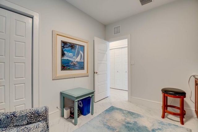 living area featuring baseboards, marble finish floor, and visible vents