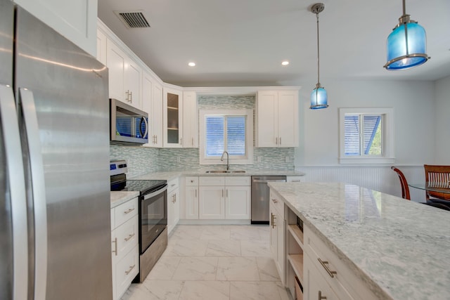 kitchen with visible vents, marble finish floor, appliances with stainless steel finishes, a sink, and wainscoting