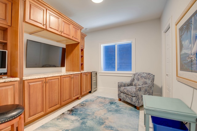 living area featuring baseboards and wine cooler