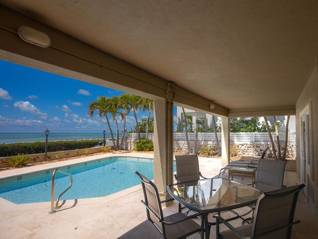 view of swimming pool featuring a fenced backyard, a patio area, a water view, and a fenced in pool