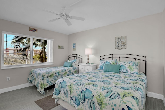 bedroom featuring ceiling fan, wood finished floors, and baseboards