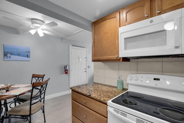 kitchen featuring white appliances, baseboards, decorative backsplash, brown cabinetry, and ceiling fan