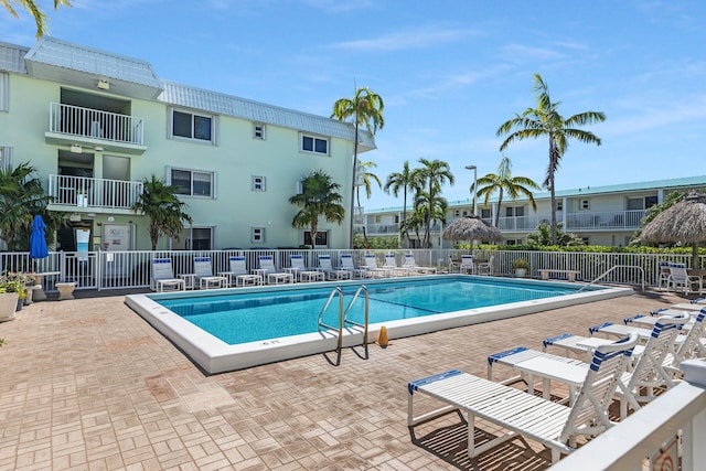 community pool with fence and a patio