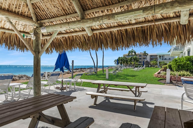 view of property's community featuring a patio area, a lawn, a gazebo, and a water view