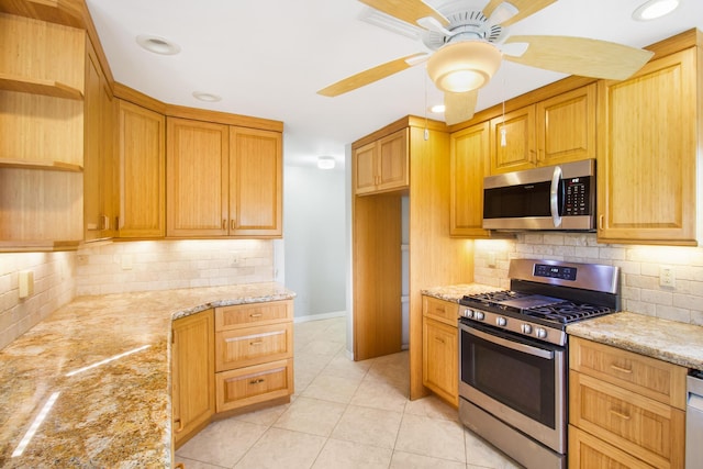 kitchen featuring appliances with stainless steel finishes, open shelves, light stone counters, and light tile patterned flooring